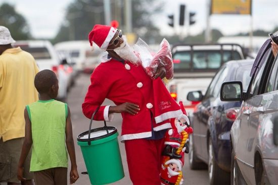 Un automovilista toma una foto de un hombre vestido como Santa Claus en las calles de Harare. La mayoría de las personas en este próspero país de África meridional están luchando para permitirse el lujo de Navidad a medida que la economía implosione.