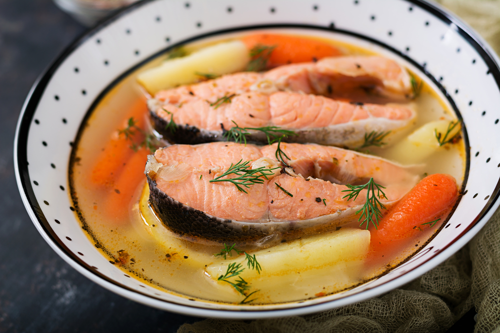Salmon fish soup with vegetables in bowl.