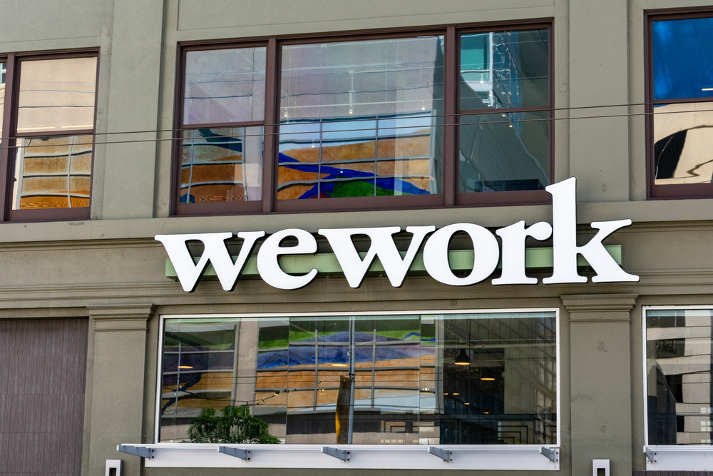 WeWork sign on shared coworking space. The We Company is an American commercial real estate company that provides shared workspaces for technology startups - San Francisco, California, USA - 2019