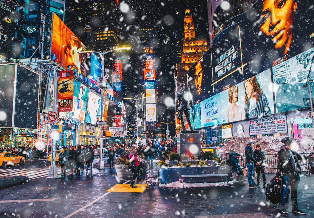 New York City, USA - March 18, 2017: People and famous led advertising panels in Times Square during snow, one of the symbol of New York City.