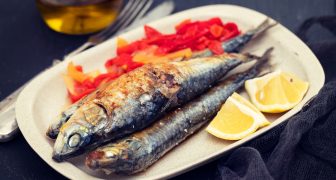 Grilled sardines with red pepper and lemon on dish