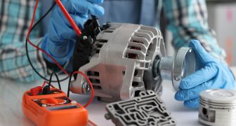 Automotive alternator repair test stator closeup with copper coil in workshop. Checking generator with multimeter