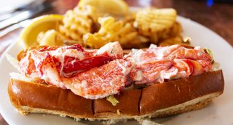 A fresh lobster roll served with waffle fries in a restaurant in Portland Maine.