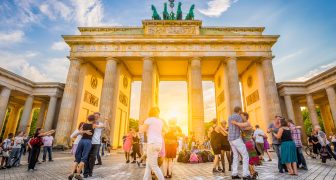 People dancing in front of famous Brandenburg Gate at sunset, Berlin, Germany