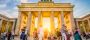 People dancing in front of famous Brandenburg Gate at sunset, Berlin, Germany