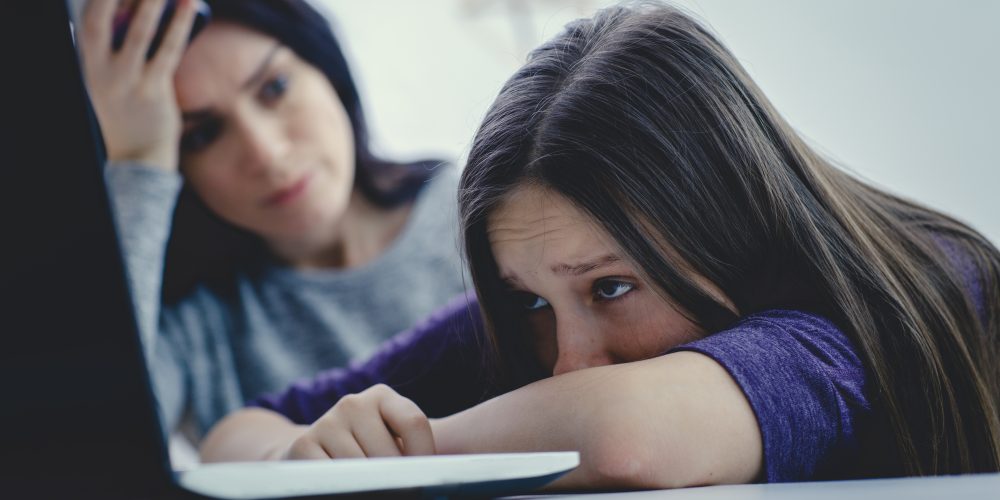 Scared mother arguing daughter over online activity. Cyber bullying or blue whale game concept