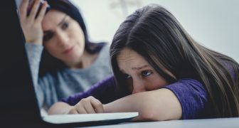 Scared mother arguing daughter over online activity. Cyber bullying or blue whale game concept