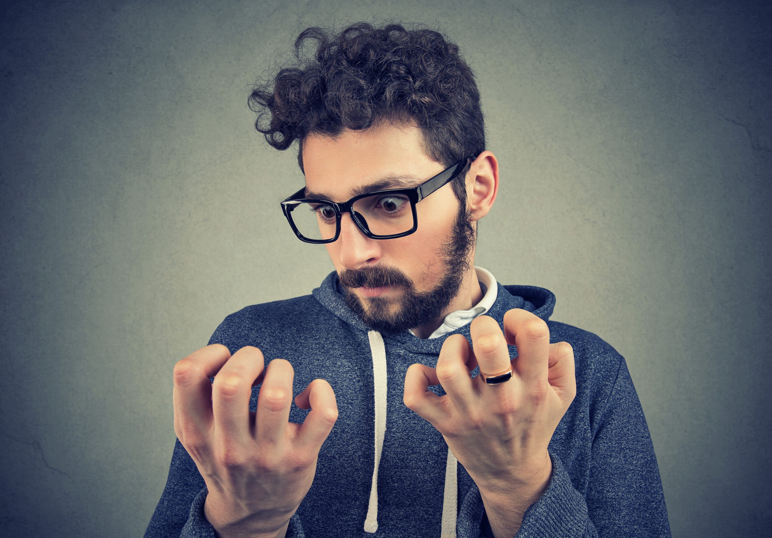 Young serious man with obsessive compulsive disorder exploring cleanliness of hands.