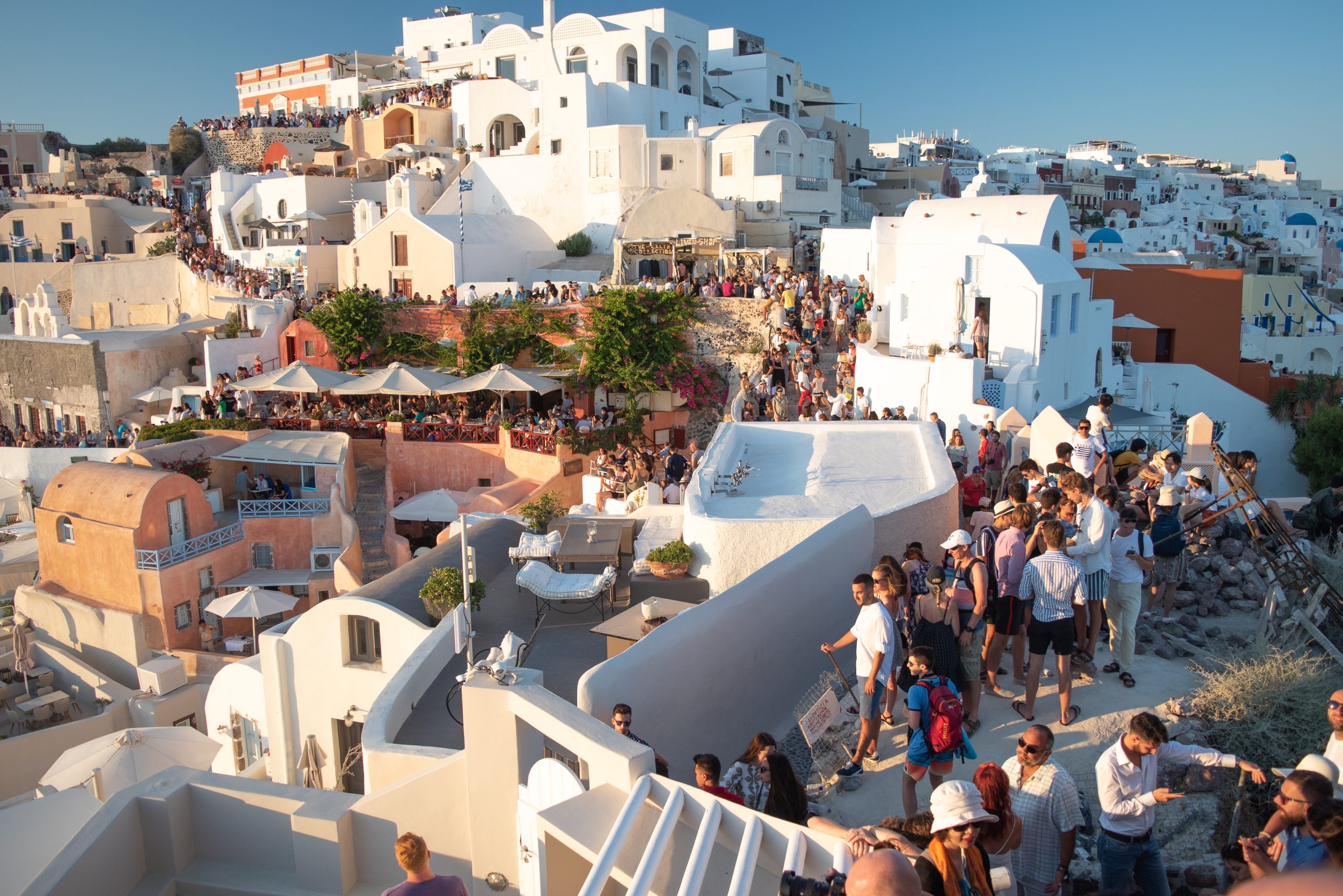 SANTORINI, GREECE - JULY 18 2019: Beautiful village of Oia crowded full of tourists for the sunset, Santorini island, Greece.
