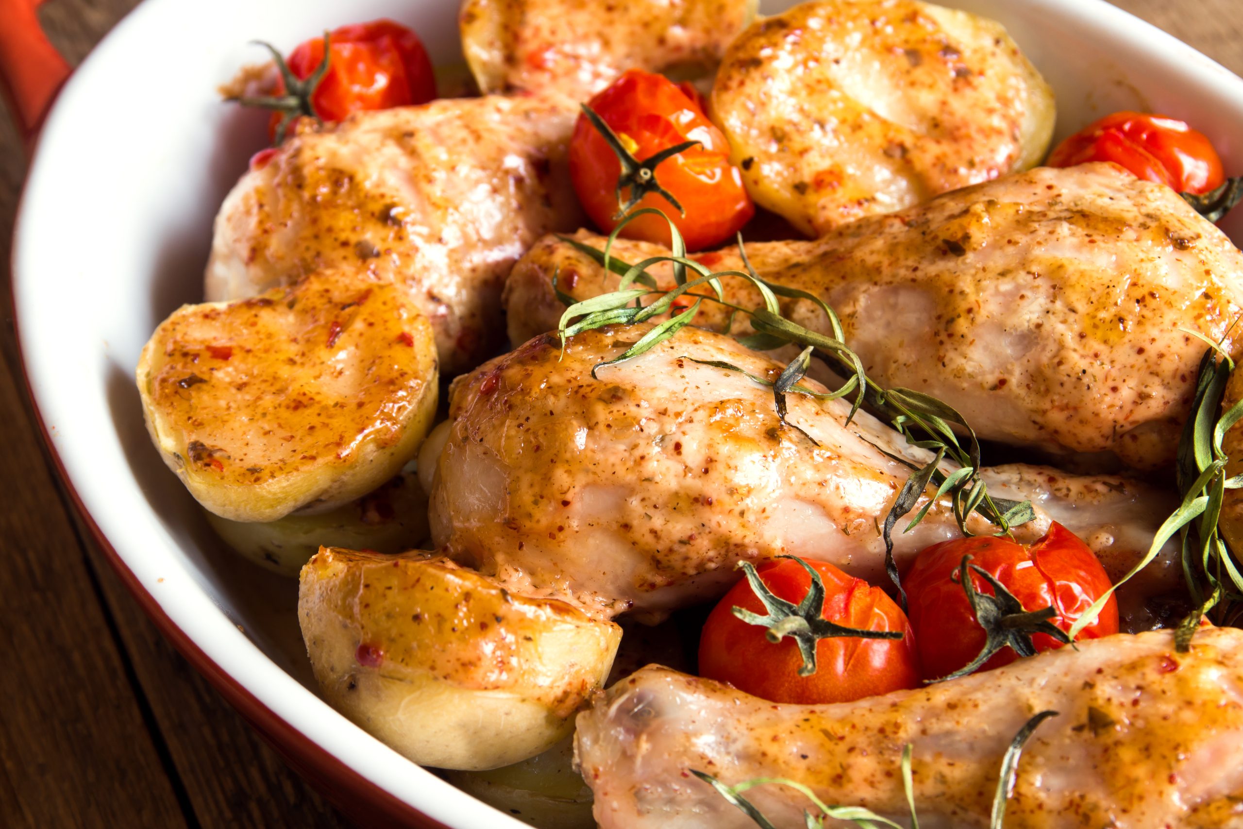 Oven baked chicken legs wiht vegetables (tomatoes, potatoes), herbs and spices